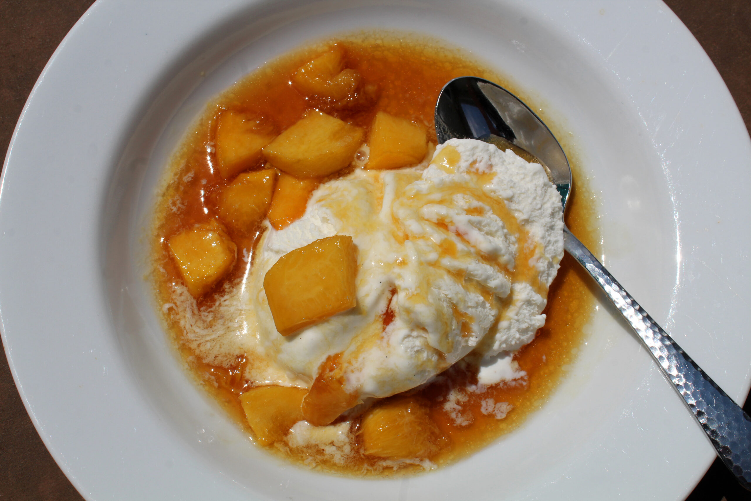 Fresh peach reduction sauce with vanilla bean ice cream is rich, decadent and easy